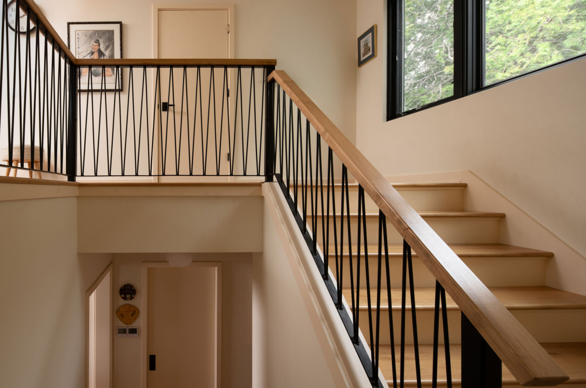 Mid-century modern staircase with wood treads and black metal railing in Wisconsin home